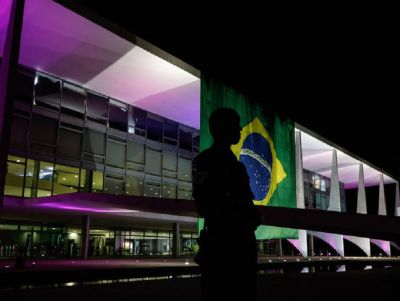 Presidente estende bandeira gigante do Brasil na fachada do Planalto